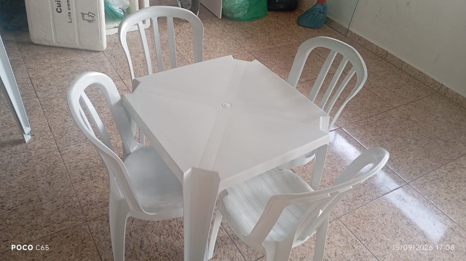 Mesa com 4 cadeiras de plástico, ideal para festa.